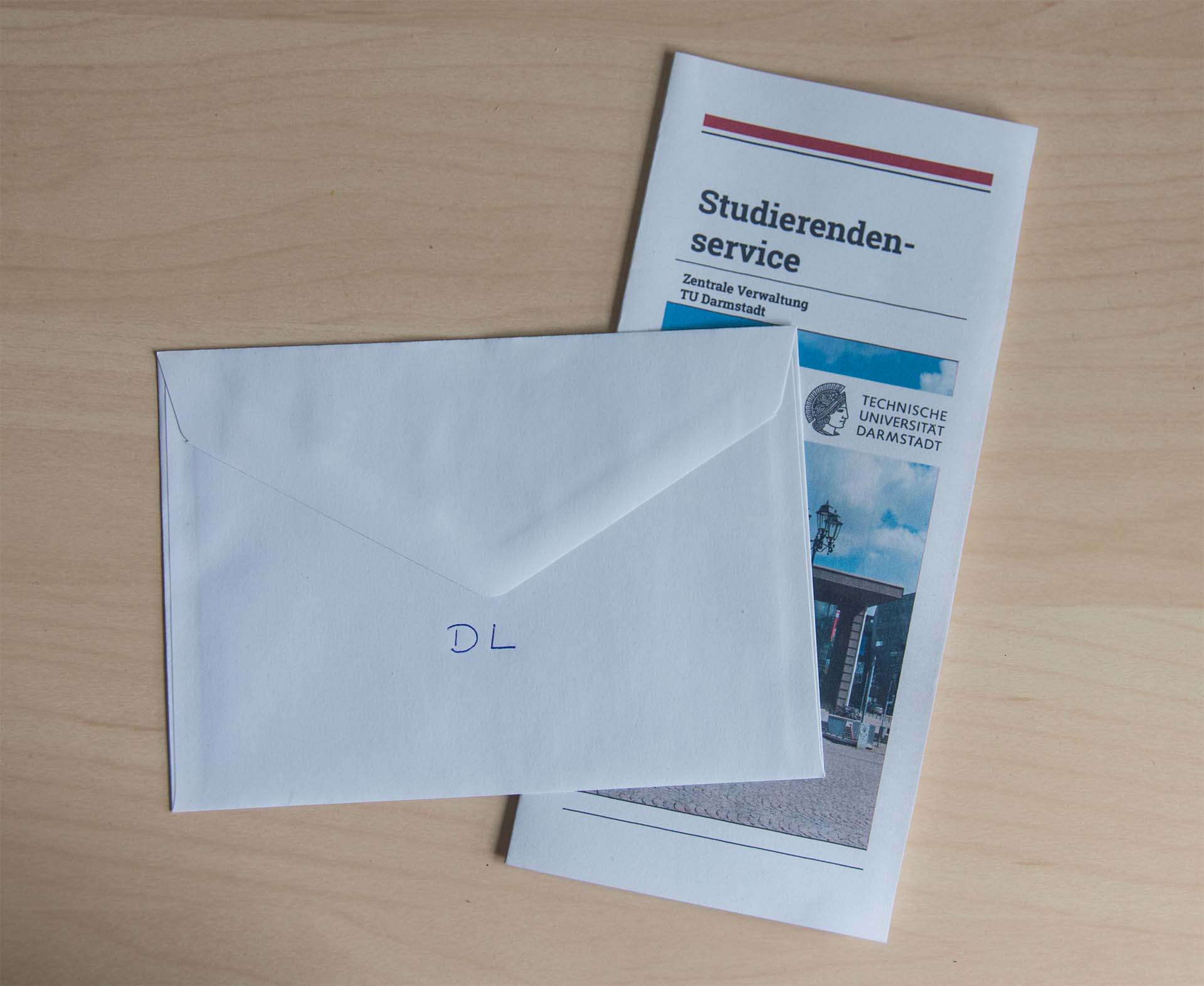 Umschlag beschriftet mit „DL“ auf einem Flyer der TU Darmstadt